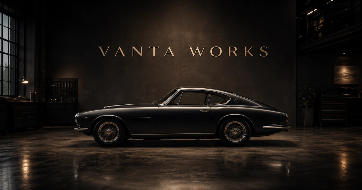 VANTA WORKS wordmark above a dark side-profile classic coupe in a restrained technical atelier.